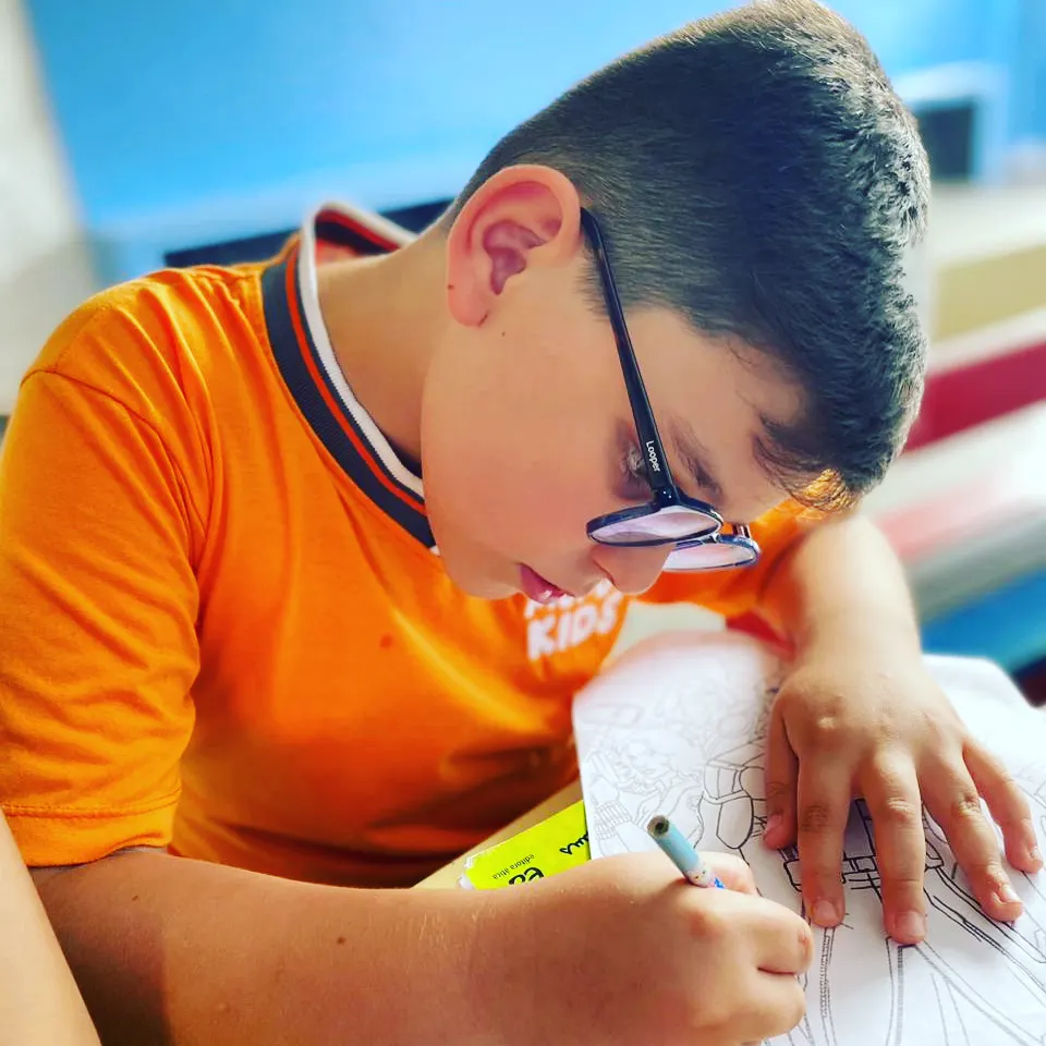Criança concentrada em atividade de desenho